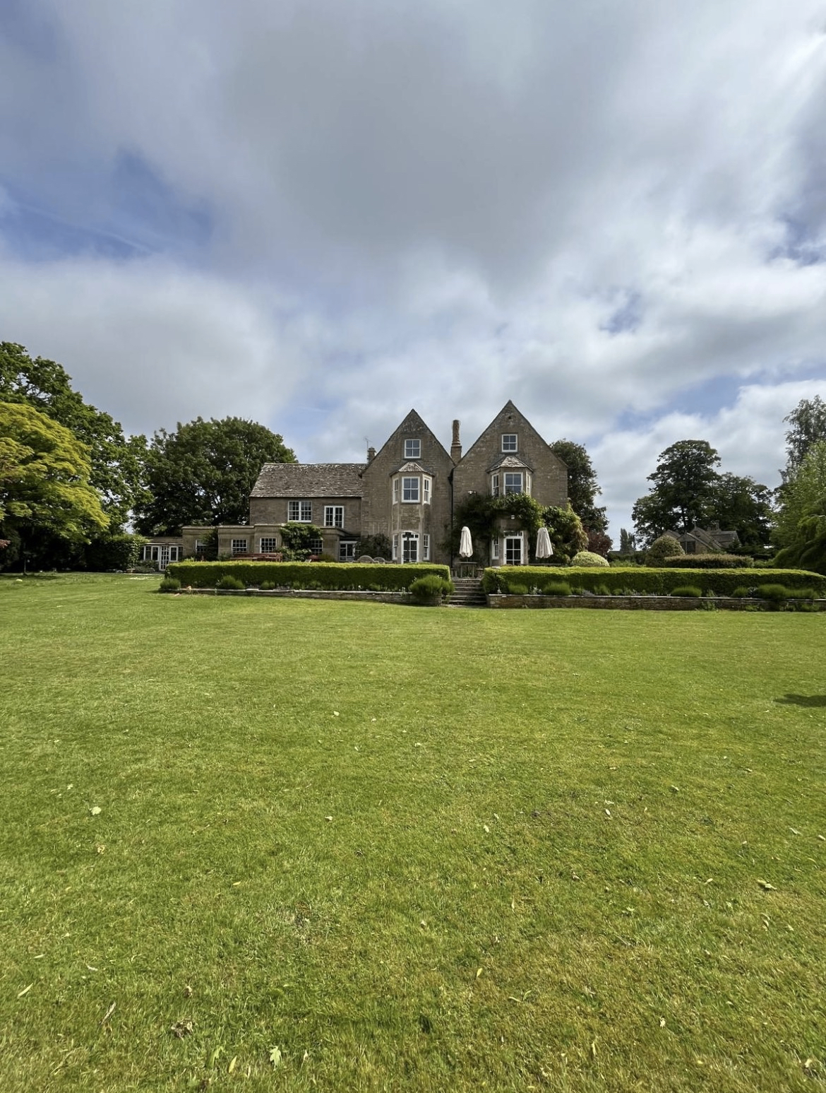 Cotswold stone manor house with manicured lawns